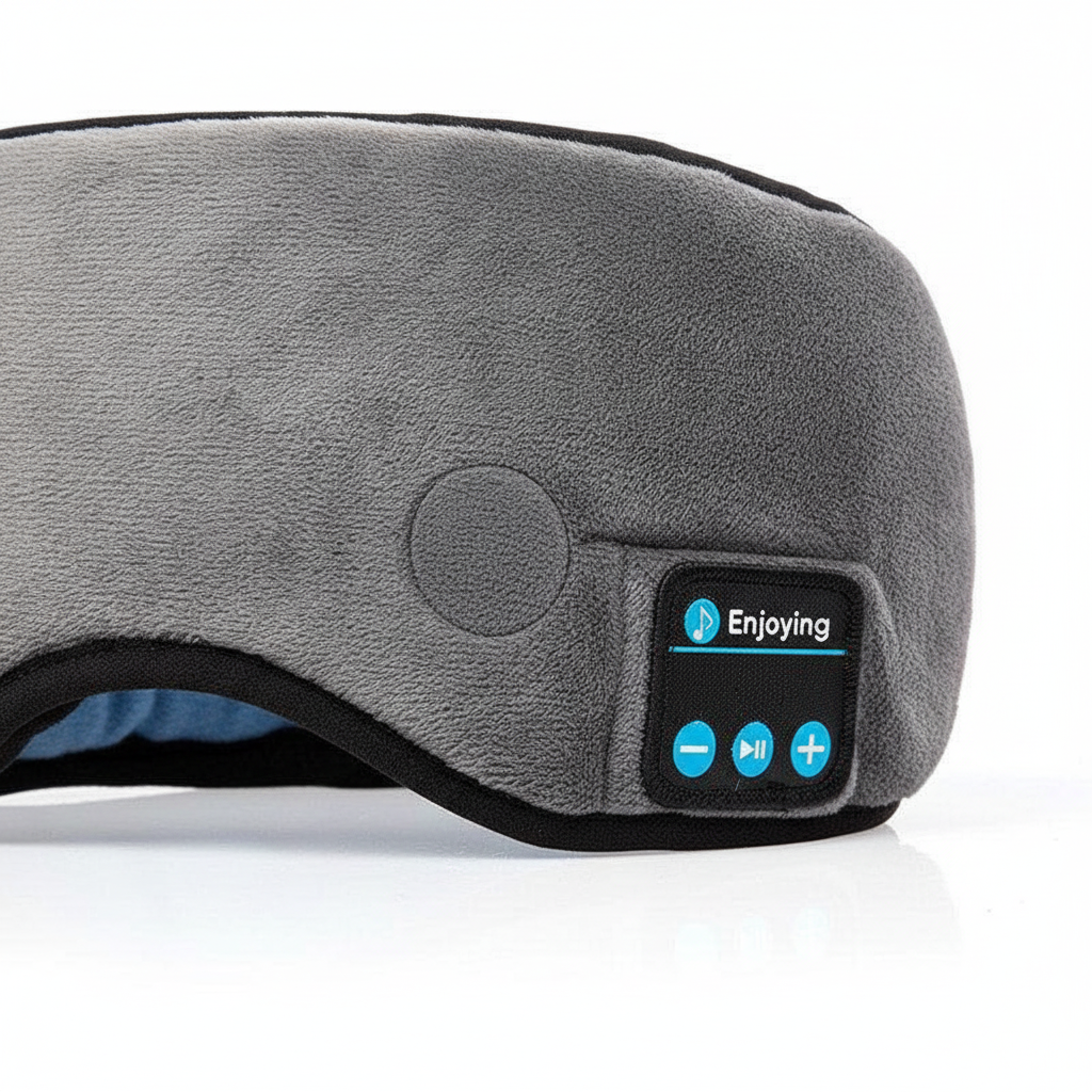 Close-up of soft gray fabric sleep mask with built-in speakers and control panel for volume and playback